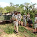Safari guide instructing group in the bush