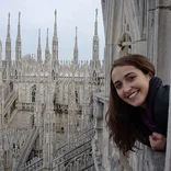student poking her head into view on a balcony on top of the Duomo di Milano