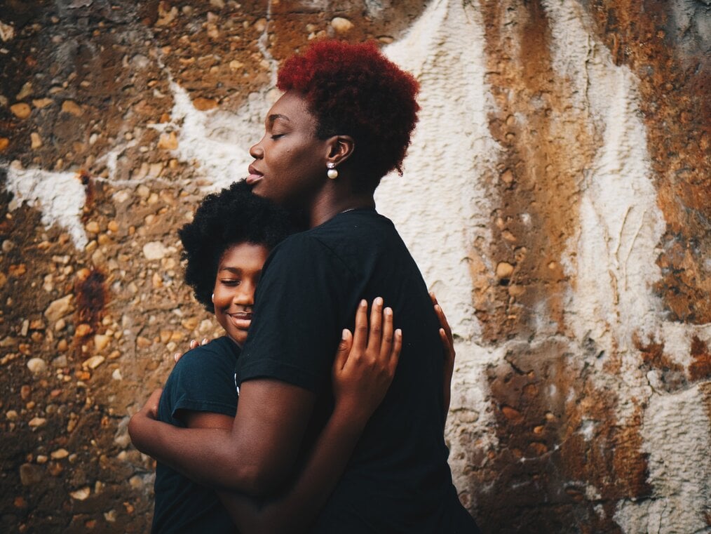 Photo by Eye for Ebony on Unsplash Two friends hugging.