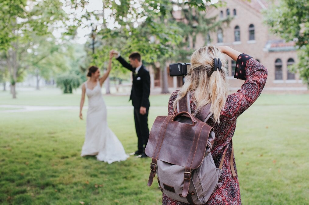 A digital nomad wedding photographer taking a picture of a bride a groom