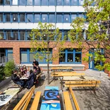 students sitting around a table in a courtyard