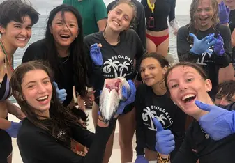 Group of teens on boat dissect fish