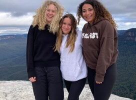 Three students on a mountaintop in Australia