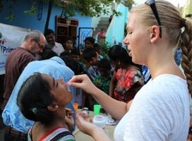 Volunteer gives a child vitamins